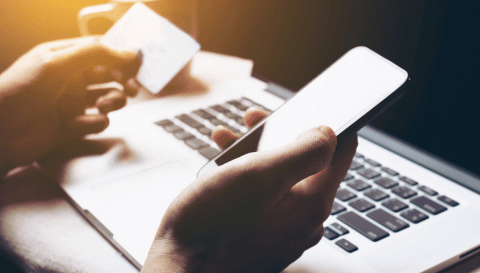 Person holding phone and credit card